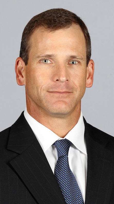 Headshot of a man wearing a dark suit.