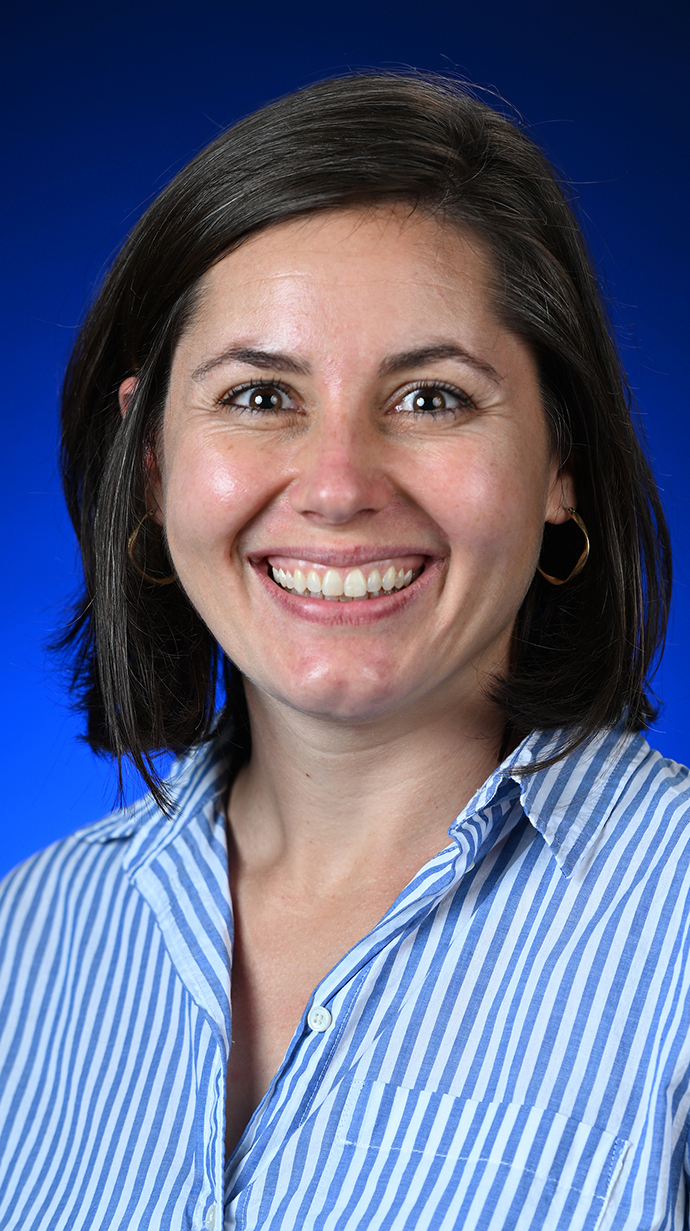 Headshot of a woman wearing a blue and white striped shirt.