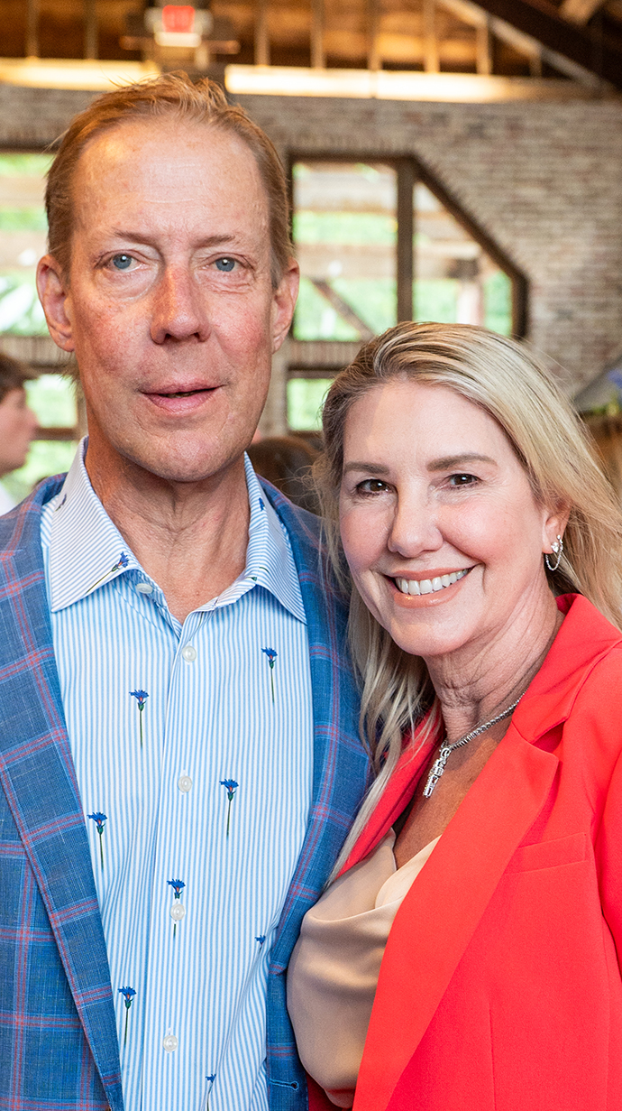 A man and a woman stand together in a meeting hall.
