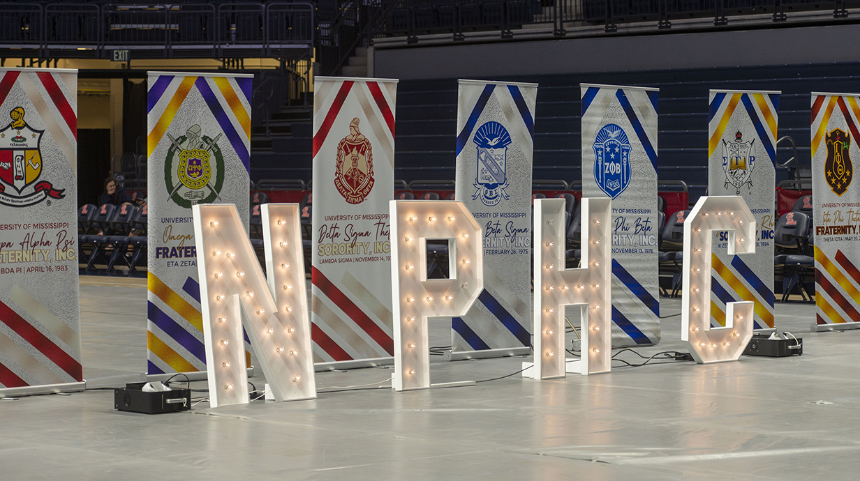 A stage display includes large letters spelling 'NPHC.'