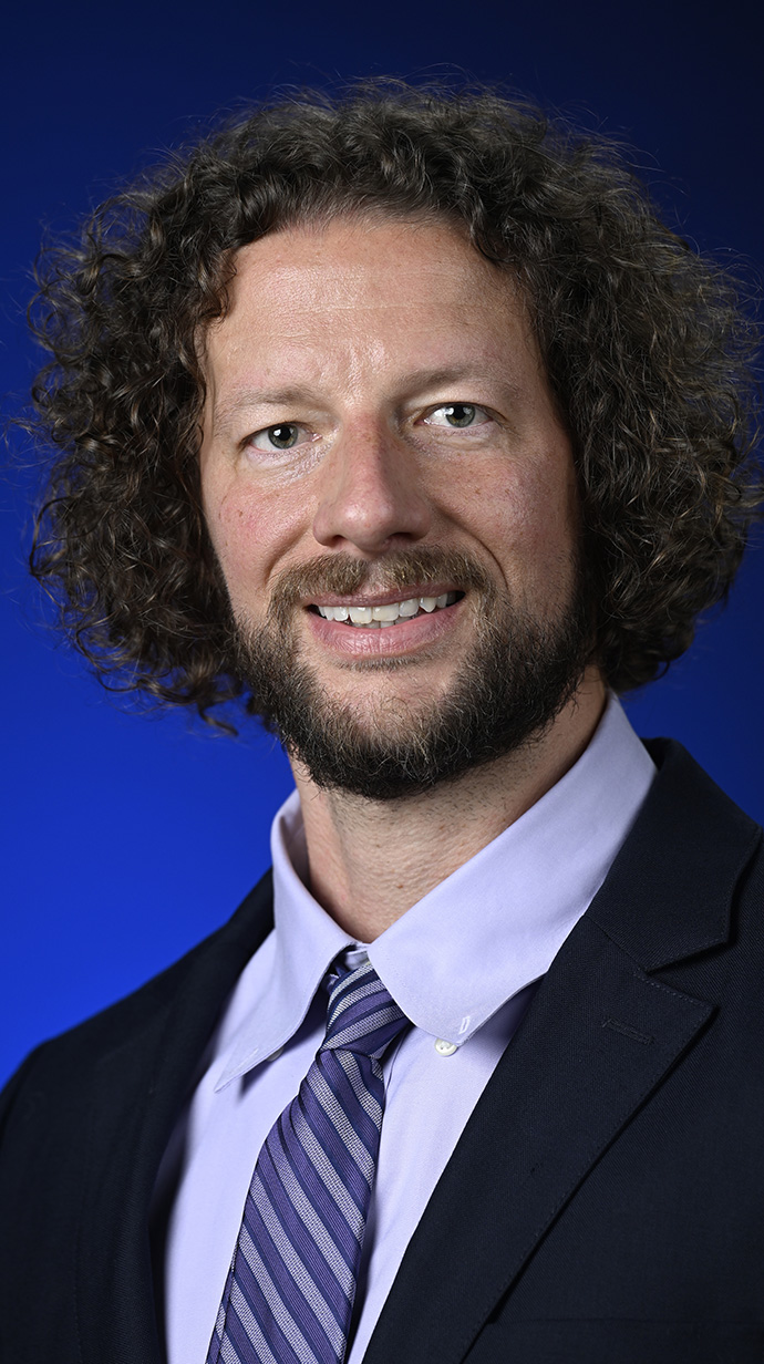 Headshot of a man wearing a dark suit.