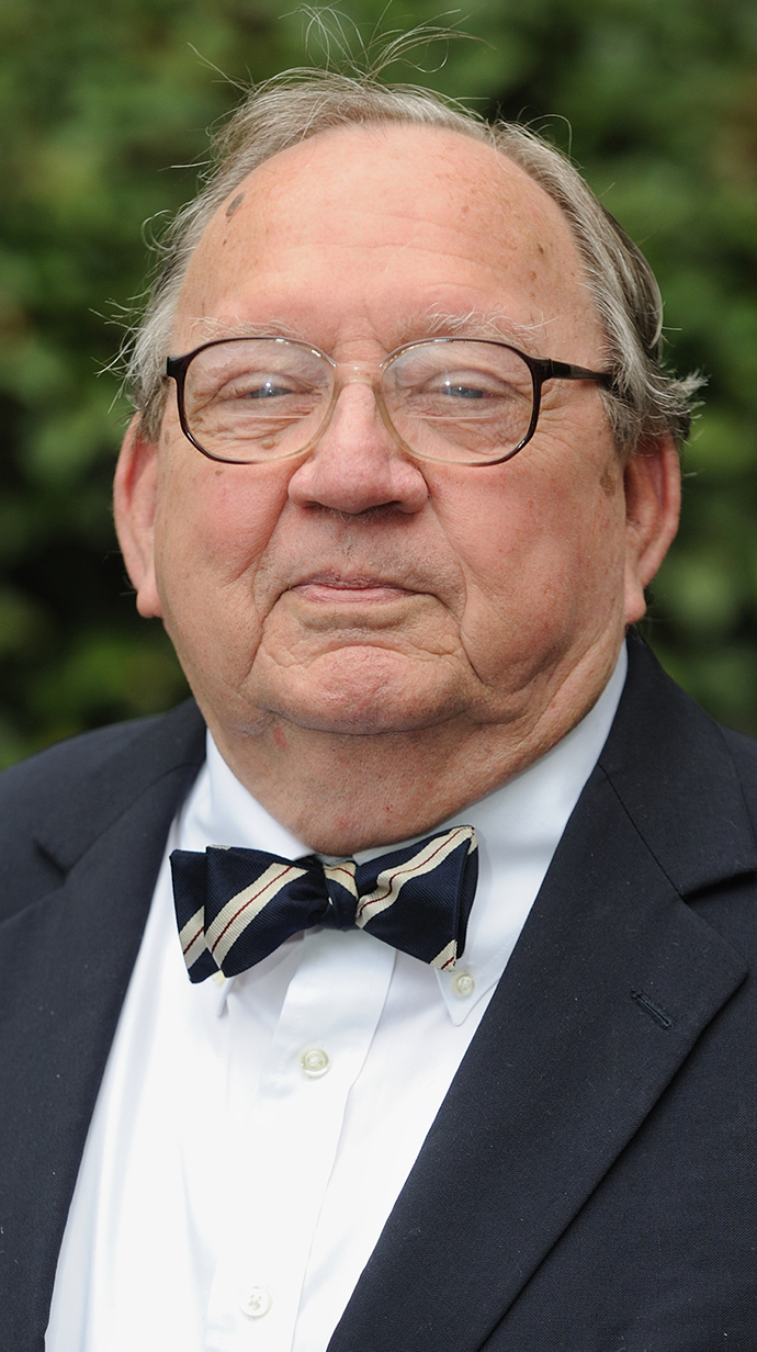Headshot of a man wearing a black suit with a bowtie.