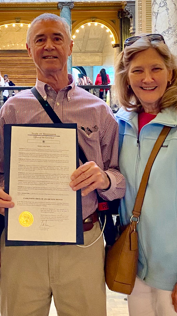 A man and a woman hold a framed certificate.