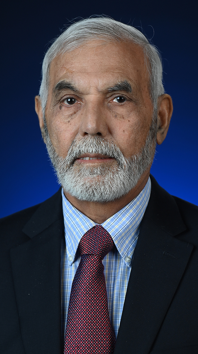 Headshot of a bearded man wearing a dark suit with a burgundy tie.
