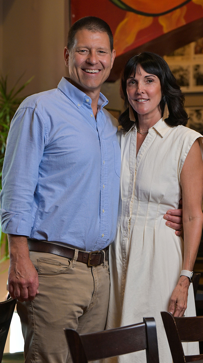 A man and a woman stand among the tables in a restaurant.