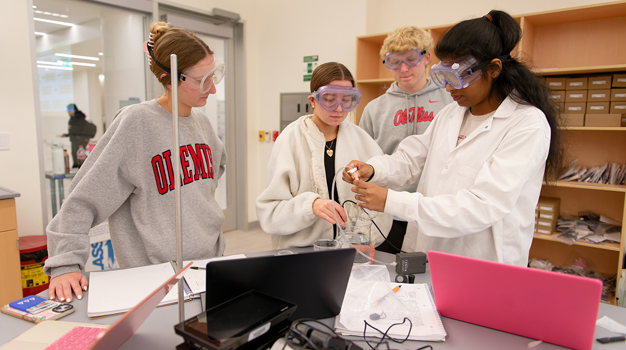 A group of young people work on an experiment in a chemistry lab.