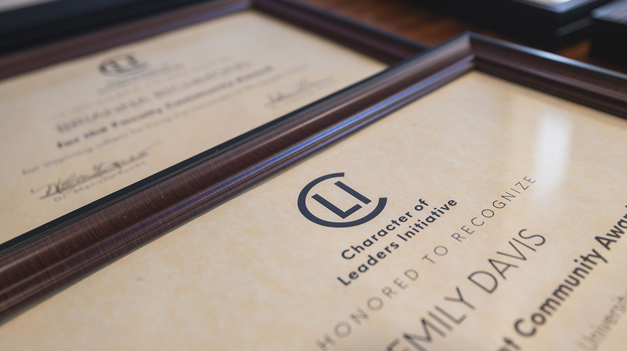 A row of framed award certificates sits on a table.