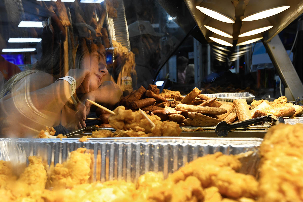 Trays of freshly fried chicken and other hot foods sit under heat lamps inside 4 Corners Chevron.