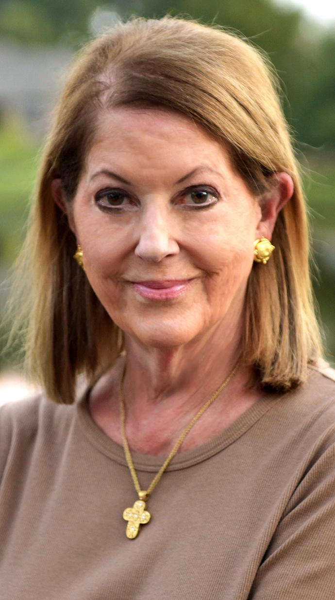 Headshot of a woman wearing a brown dress.