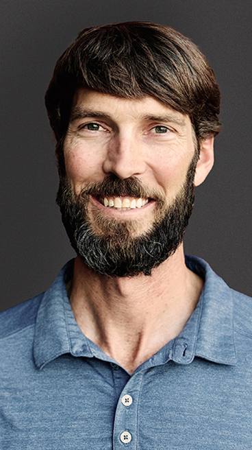 Headshot of a bearded man wearing a light blue polo shirt.