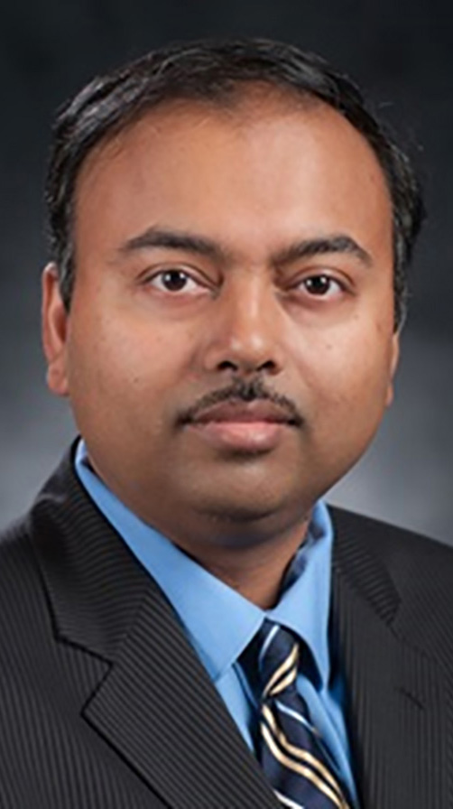 Headshot of a man wearing a dark suit.