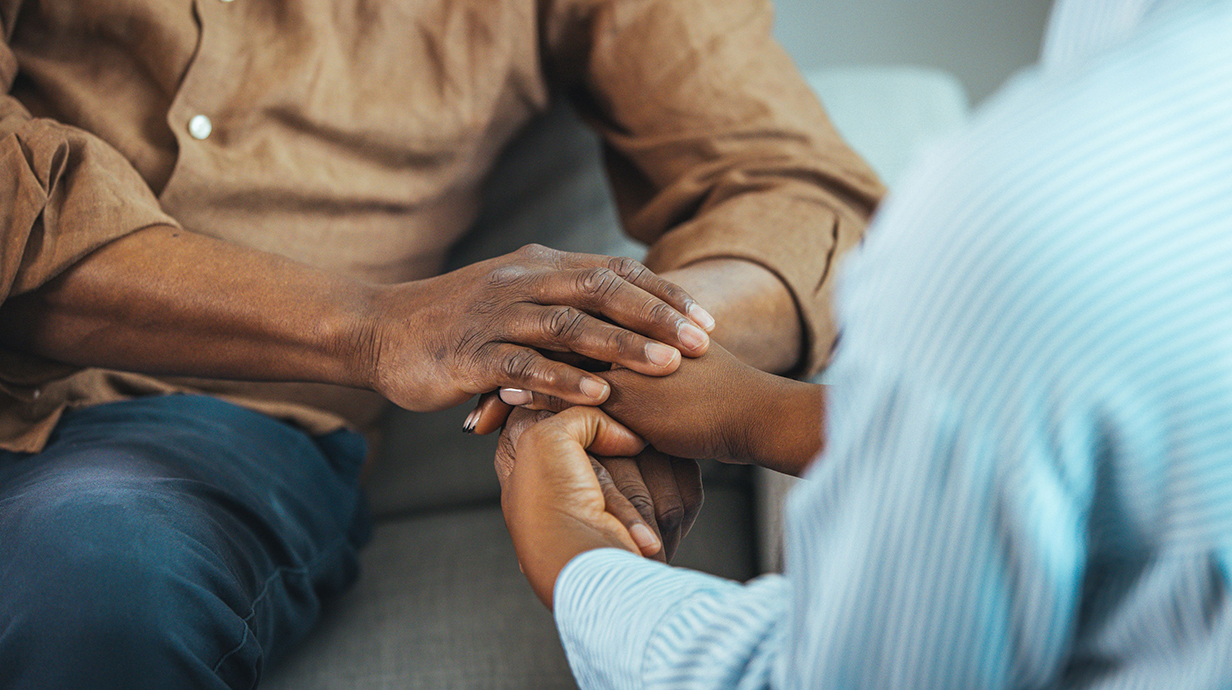 Photo of one person's hands holding another's.