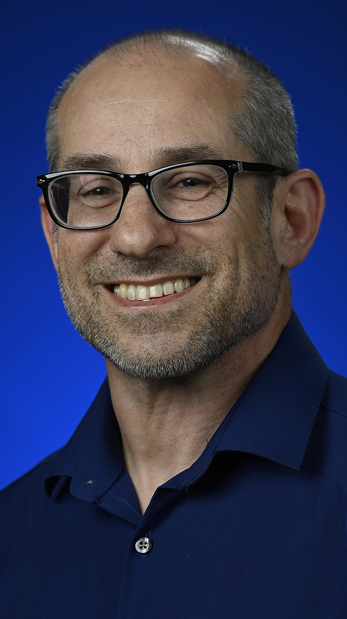 Headshot of a man wearing glasses and a black shirt.