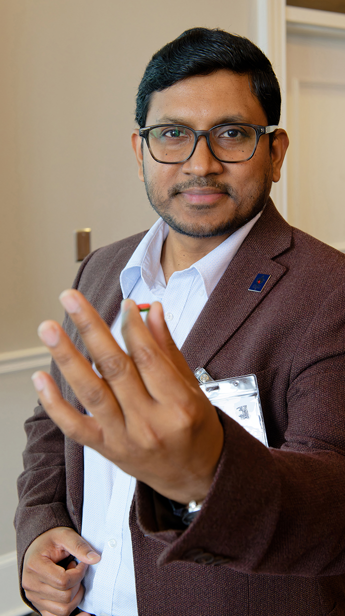 A man holds out his hand to display a pill.