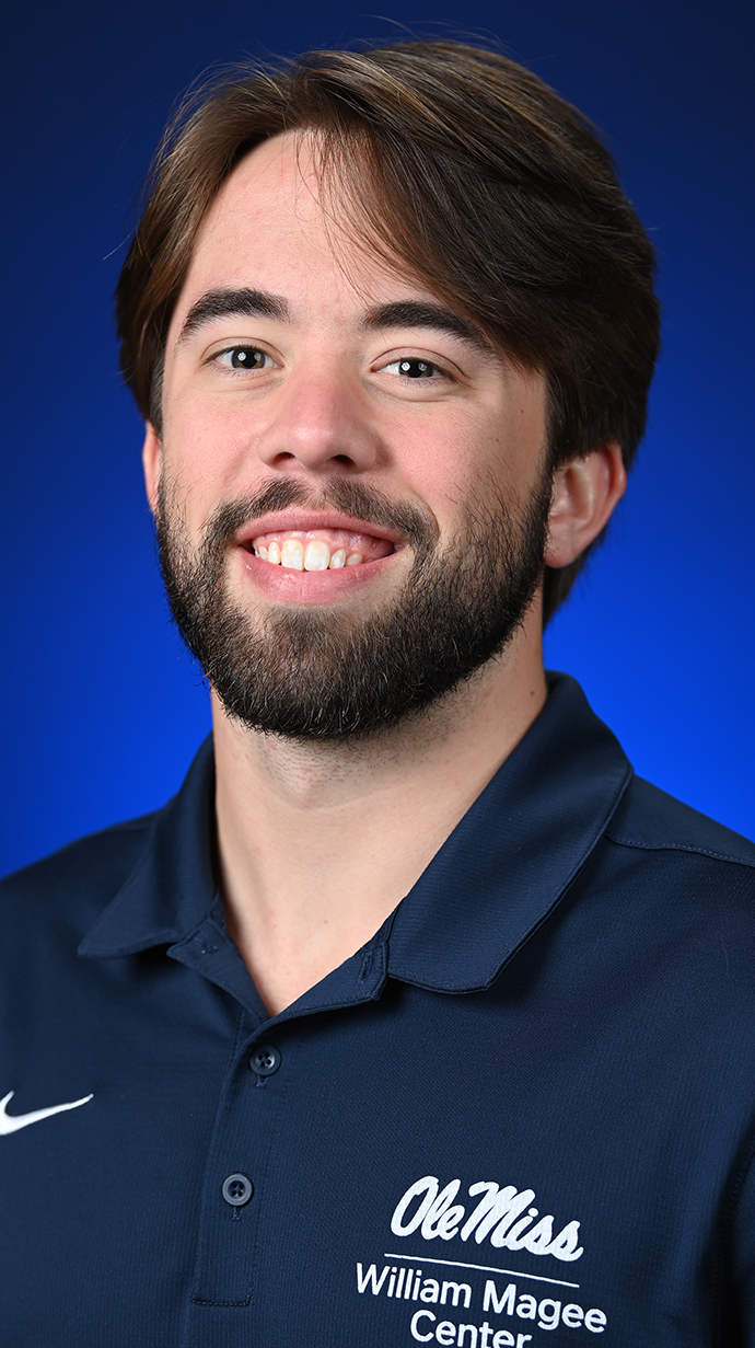 Headshot of a young man wearing a blue polo shirt with a Yniversity of Mississippi logo.