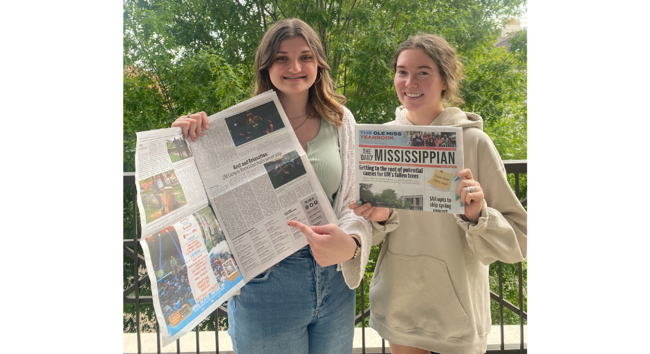 An image of Sydney Stepp and Claire Reynolds posing with an issue of the Daily Mississippian.