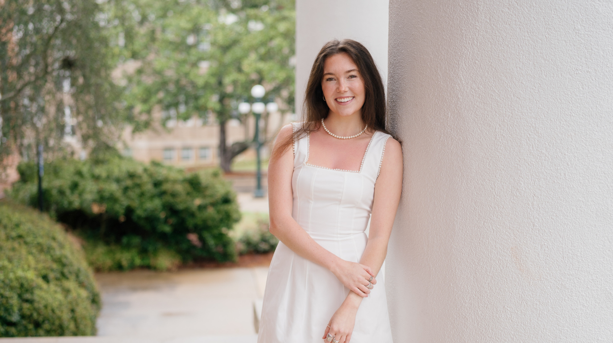 An image of Claire Reynolds leaning up against a column underneath the Lyceum.