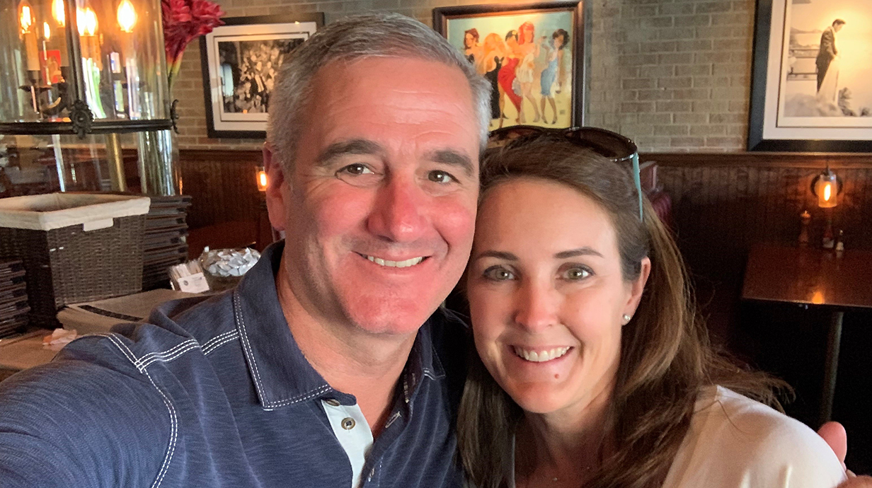 A man and a woman hug close for a selfie in a restaurant.