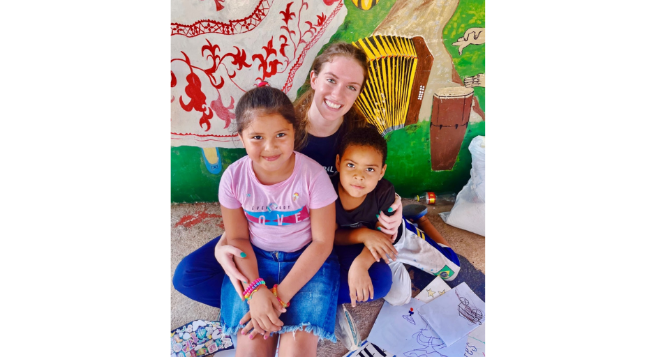 An image of Anna Owens with two children while volunteering in Panam with UM Global Brigades.