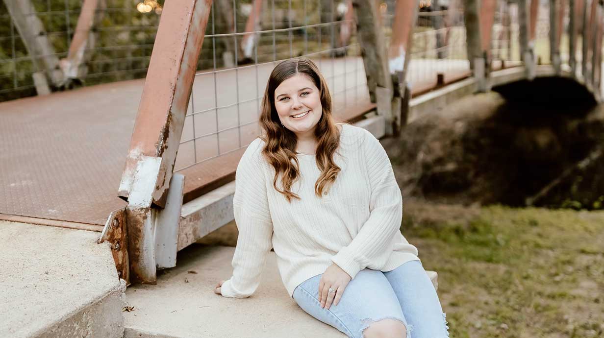 Bailee Harris sits near a footbridge.