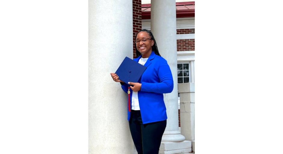 Image of Brandi Williams posing with her graduation cap.