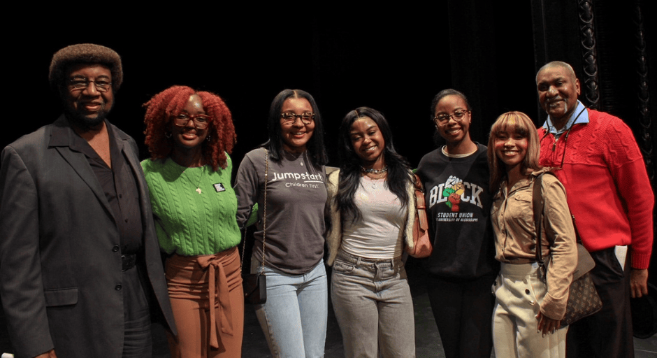 An image of Bre'Anna Coleman (second from right) smiling with six other people at the 27 Demands event.