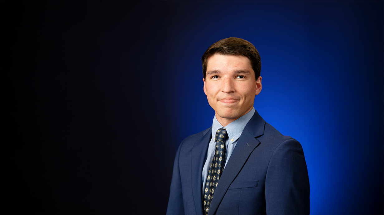 An image of Christian Boudreaux in front of a blue backdrop.