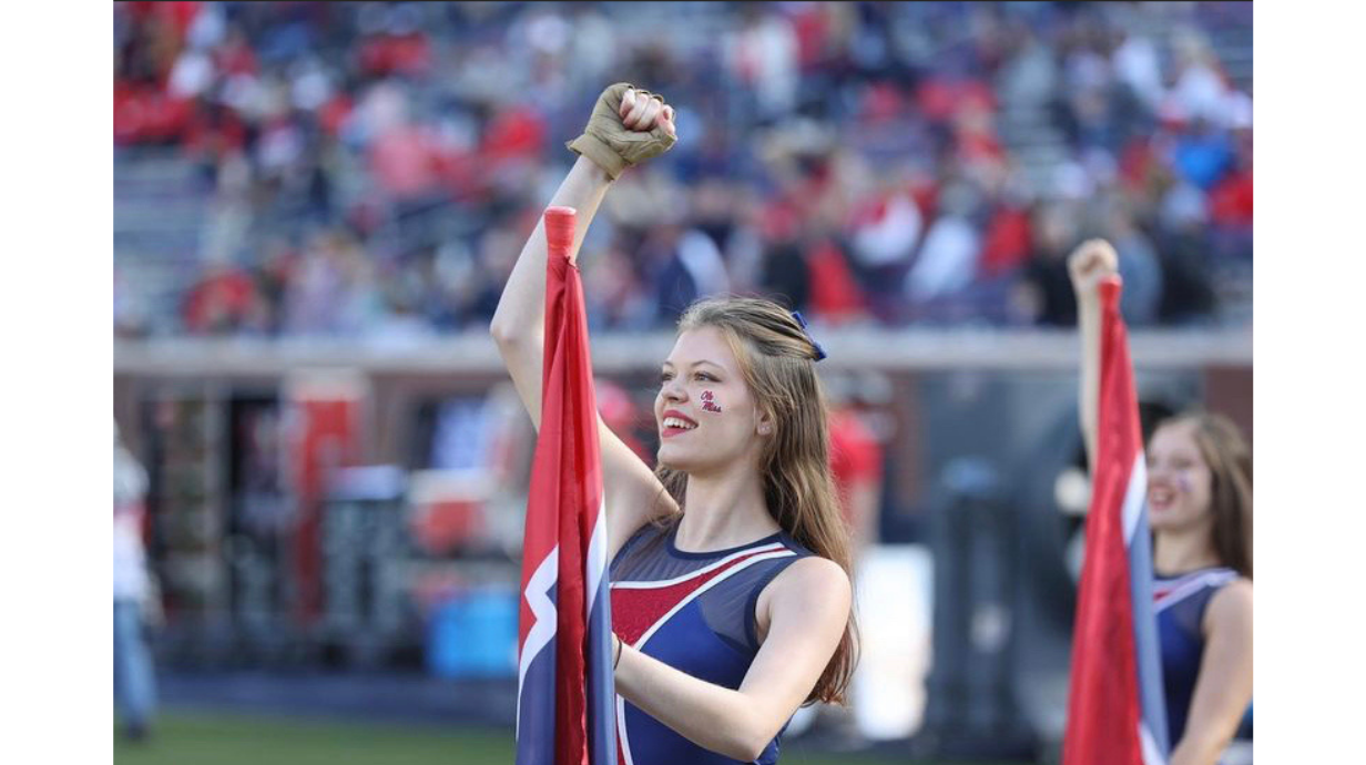 An image of Eva Renolds performing color guard at an Ole Miss football game.