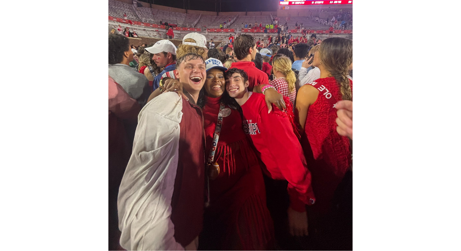 An image of Janelle Minor (center) posing with friends Ethan Robertson (left) and Nathan Snell on the football field after the 2025 football game defeating Georgia.