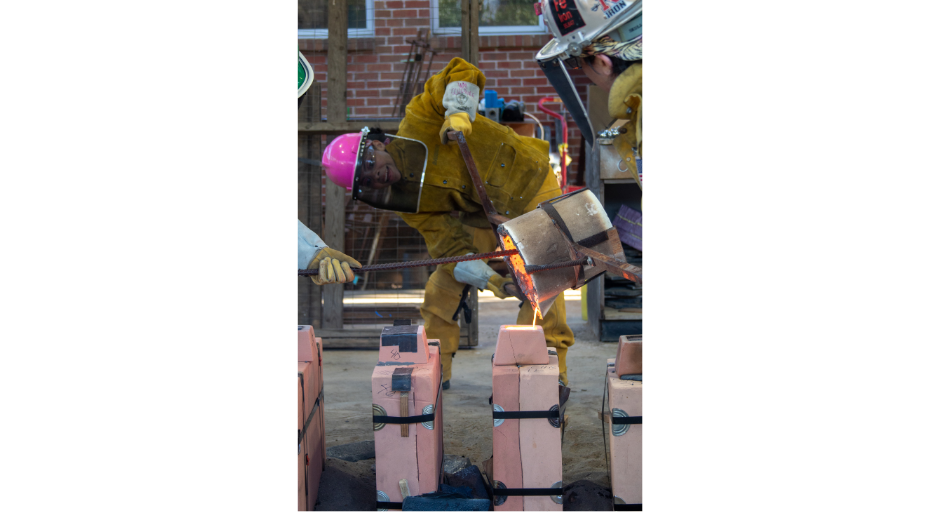 An image of Rory Randle pouring molten iron into the sand molds she created.