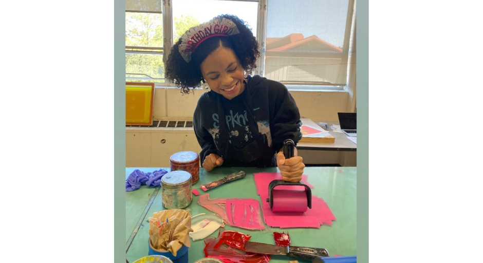 Rory Randle smiling while she works on a print on her 2024 birthday.