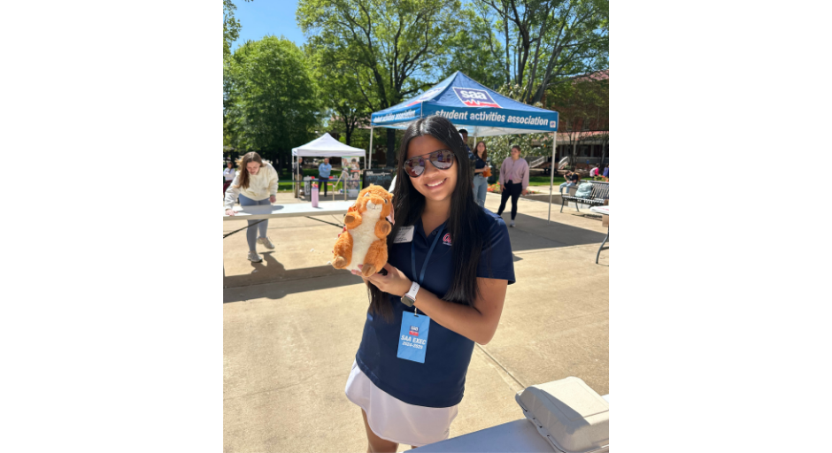 An image of Shaelen Hudson holding a plush squirrel outside of the Student Union.