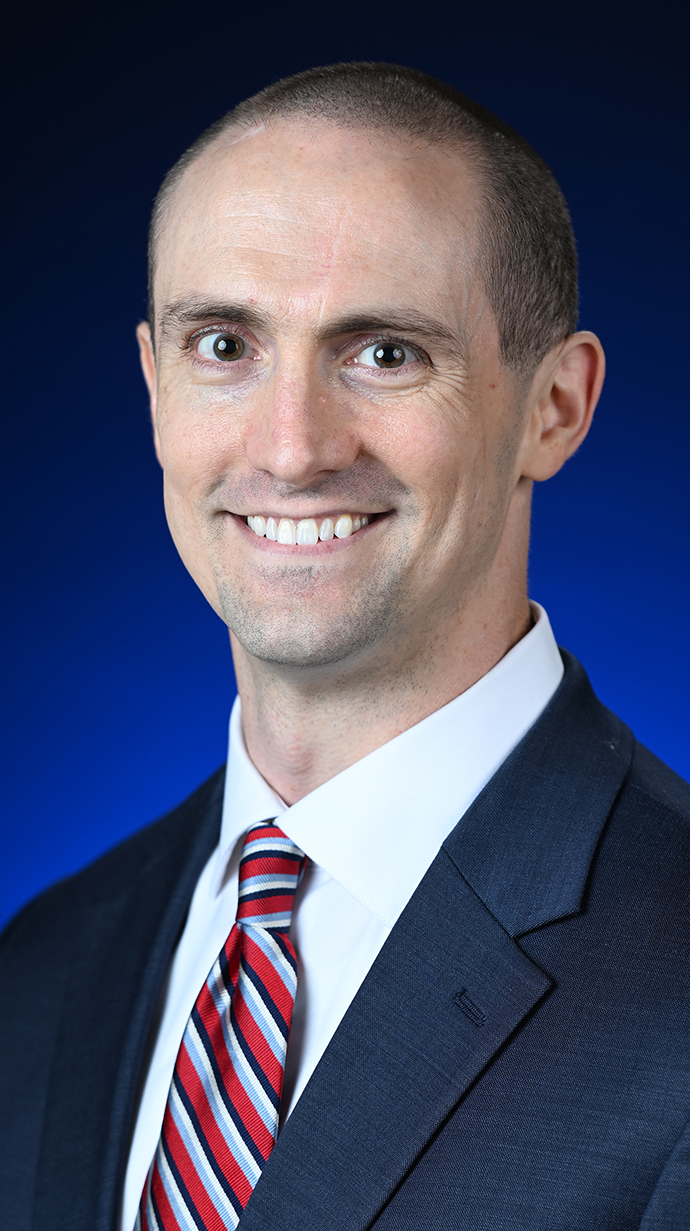 Headshot of a man wearing a dark suit.