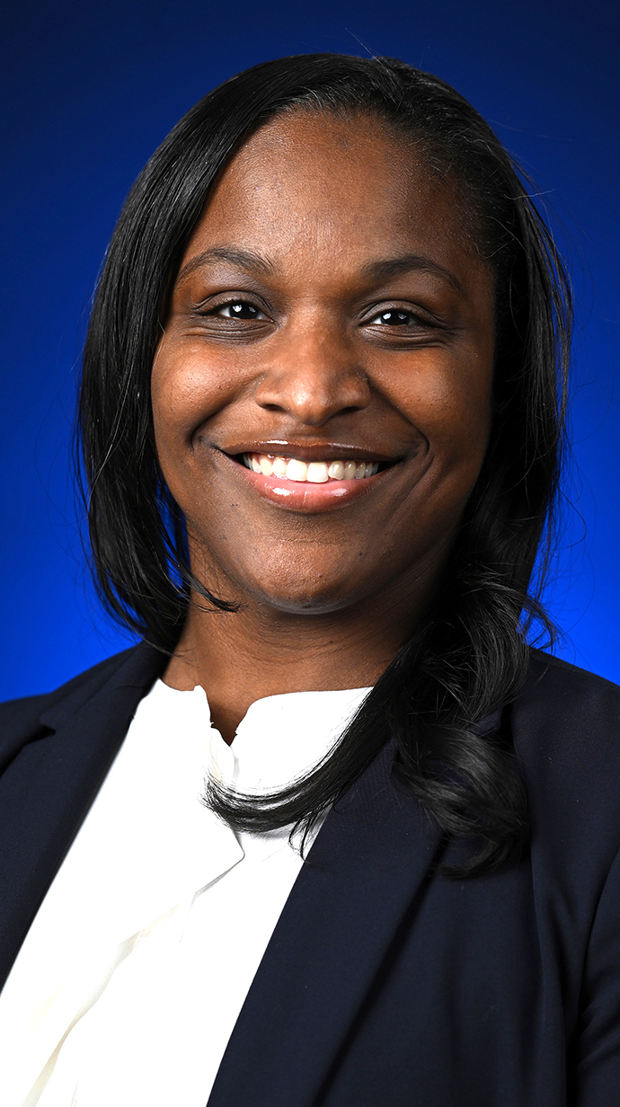Headshot of a woman wearing a dark jacket over a white blouse.