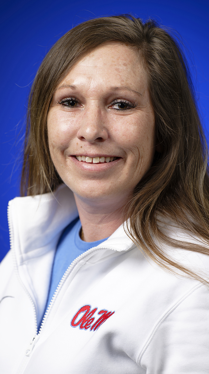 Headshot of a woman wearing a white pullover over a powder blue T-shirt.
