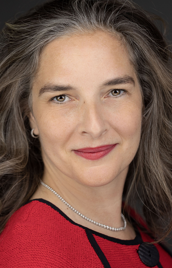 Headshot of a woman wearing a red sweater with black accents.