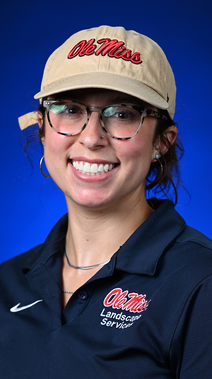 Headshot of a woman wearing a blue polo shirt and a tan Ole Miss cap.