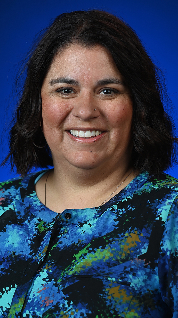 Headshot of a woman wearing a blue floral print top.
