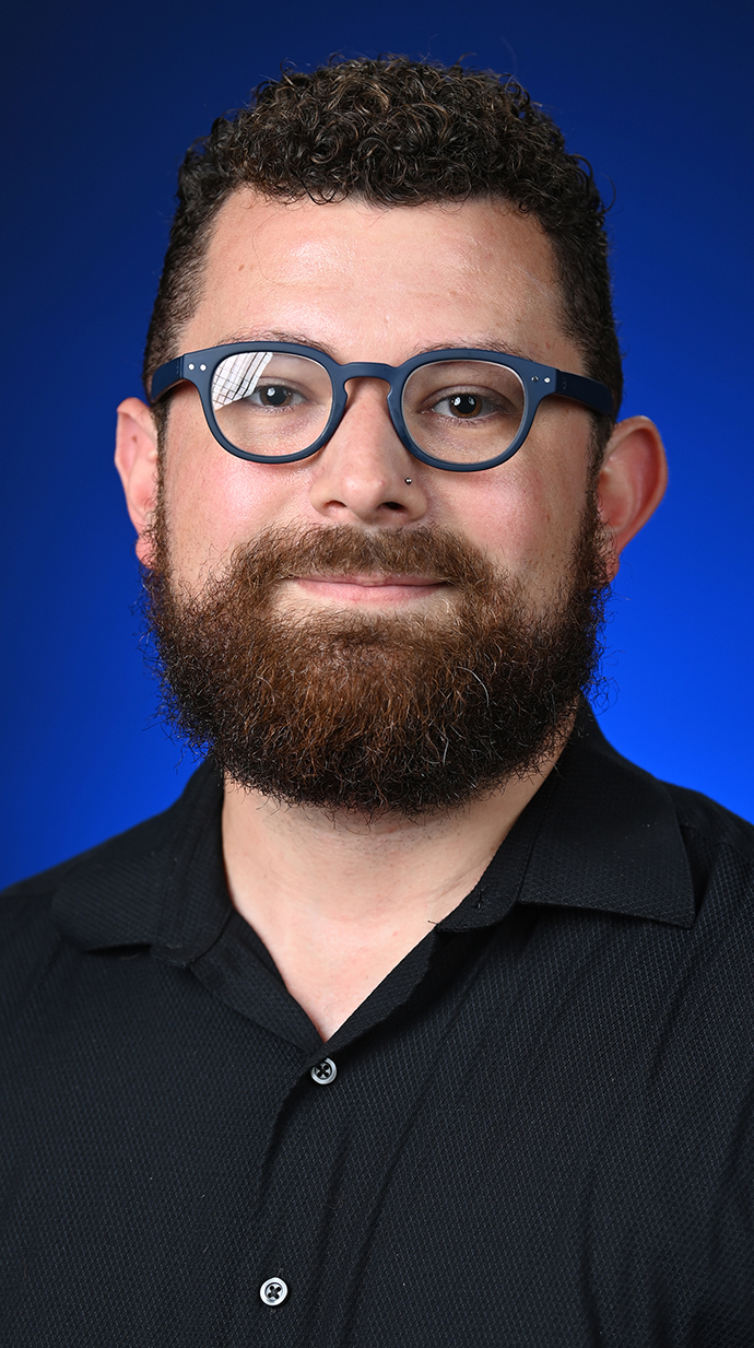 Headshot of a man wearing glasses and a black shirt.