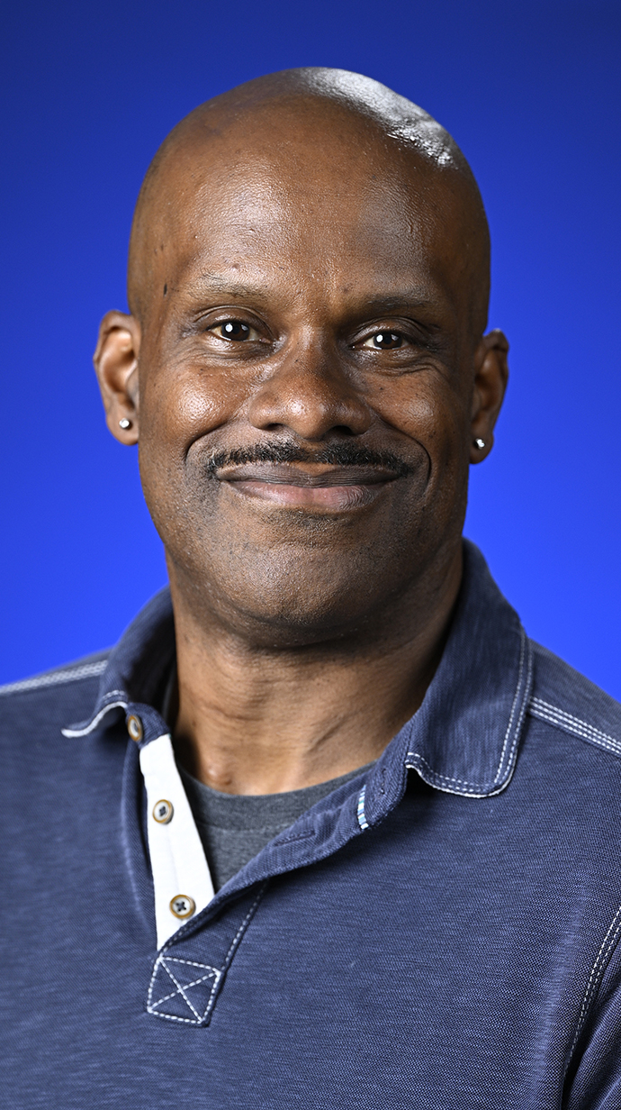 Headshot of a man wearing a blue polo shirt.