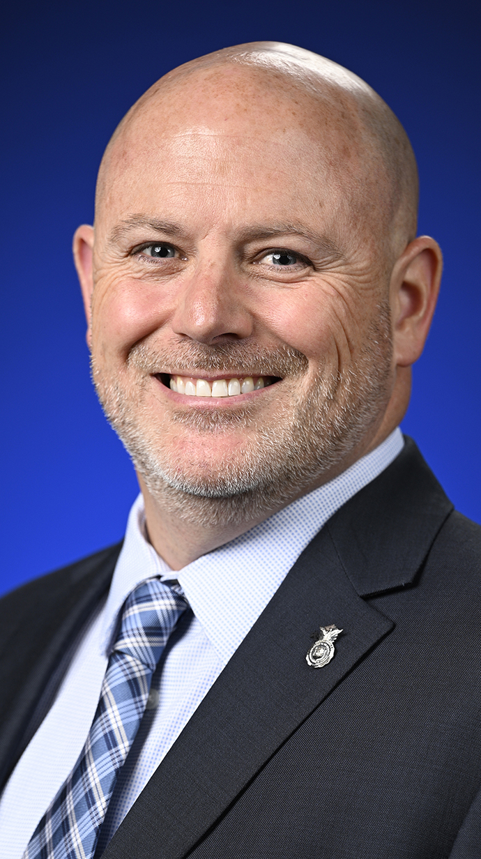 Headshot of a man wearing a dark suit.