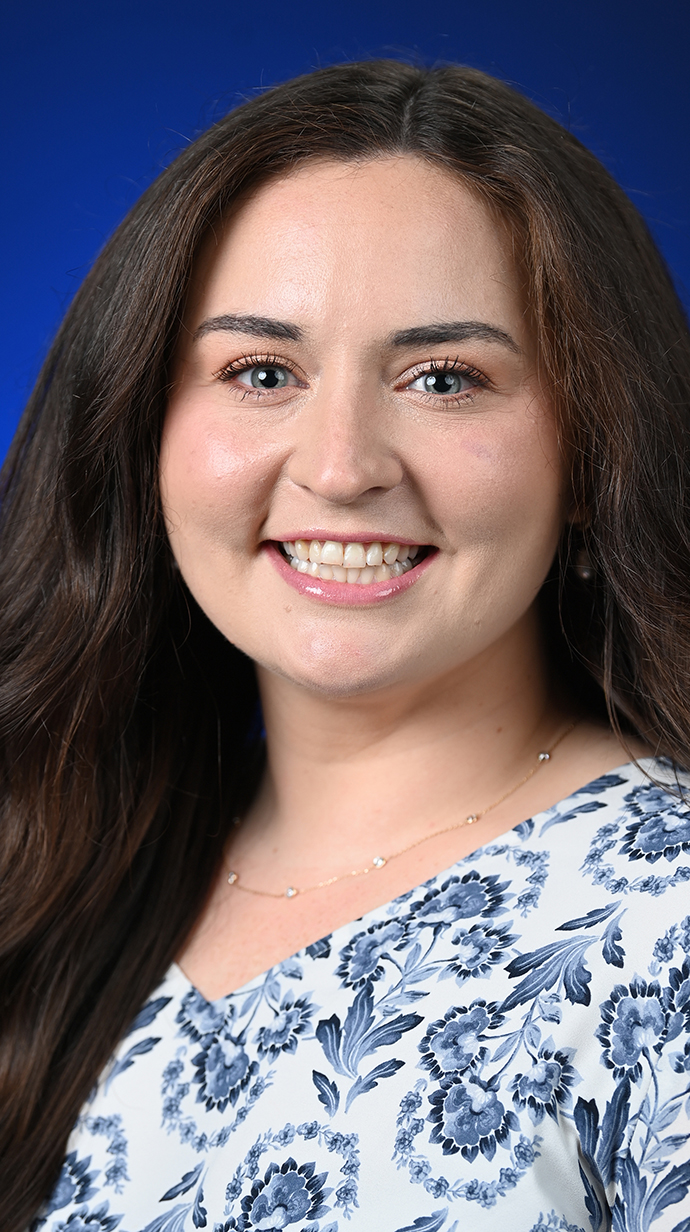 Headshot of a woman wearing a blue-and-white floral blouse.