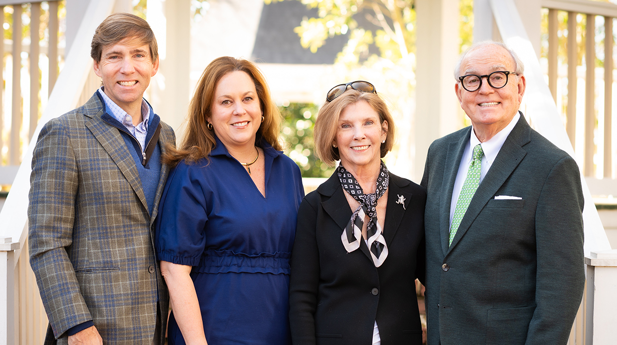 Two men and two women posed outdoors for a family photo.