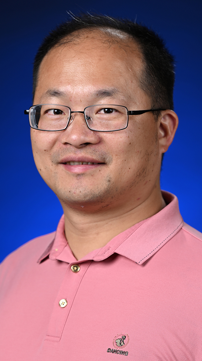 Headshot of a man wearing a pink polo shirt.