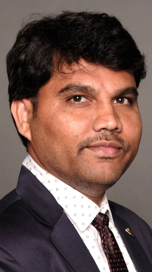 Headshot of a young man wearing a dark suit.