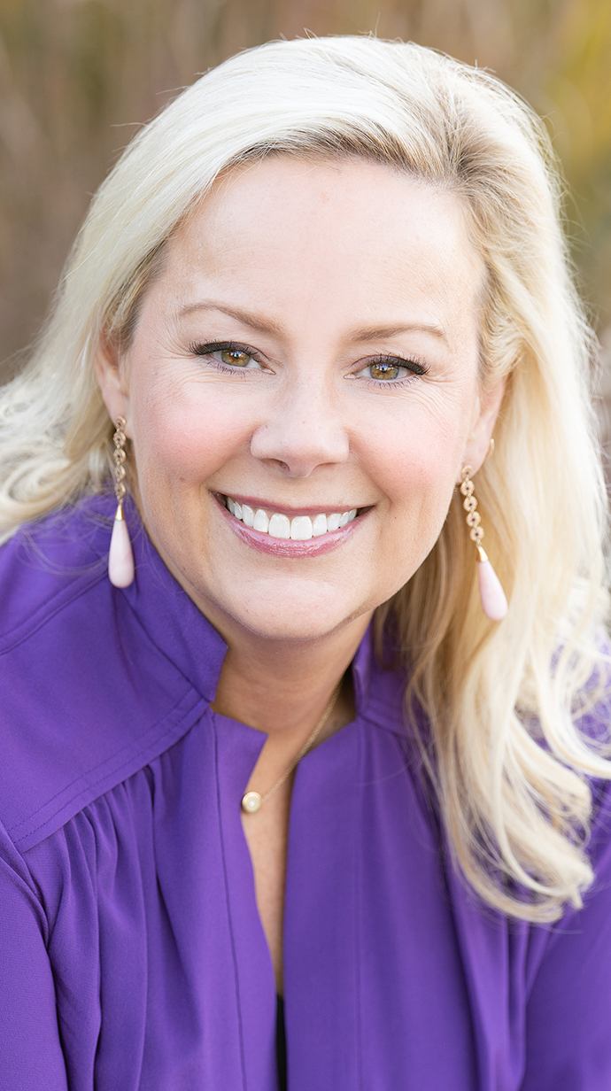 Headshot of a woman wearing a purple jacket.