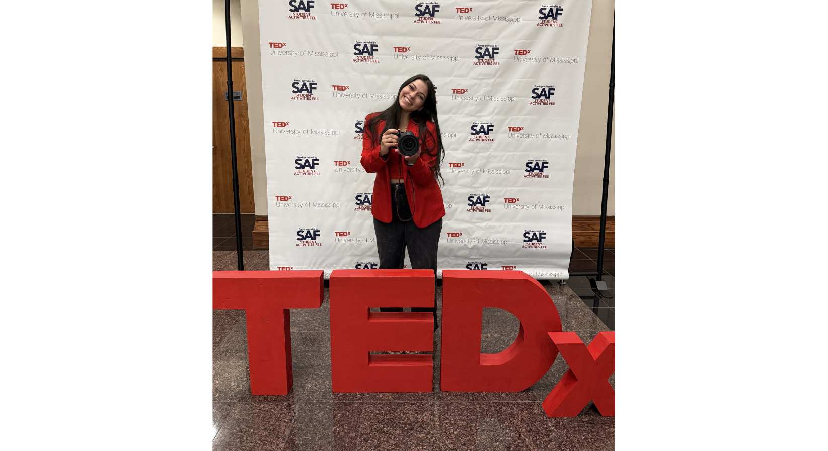 Image of Antonella Rescigno holding a camera and smiling.