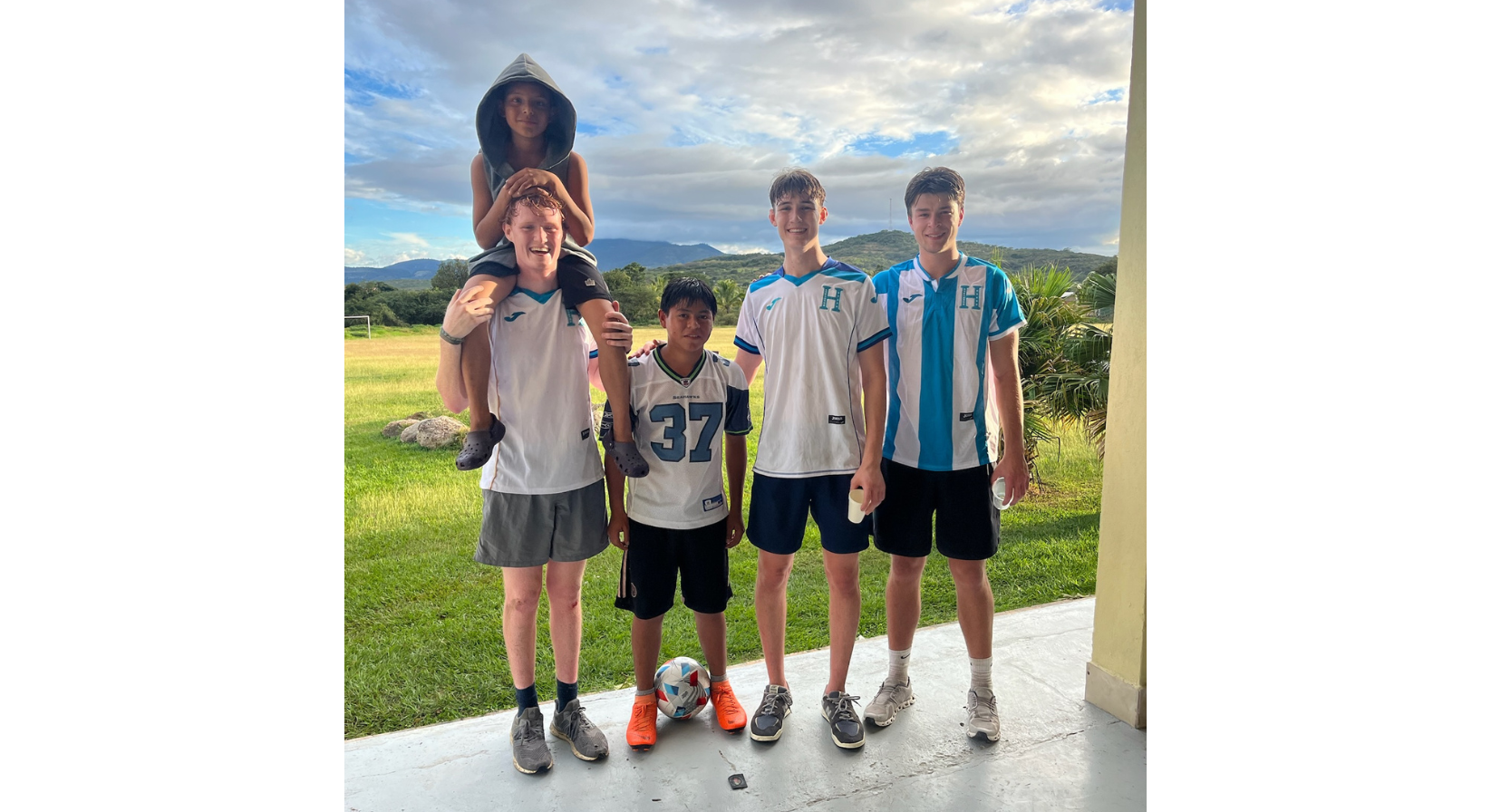 Image of Jeffrey Jordan, Wells Jordan, and Nate Paul with two children on a mission trip.