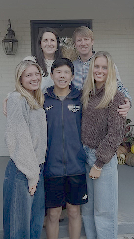 Michael takes a photo with his daughters, son and wife.