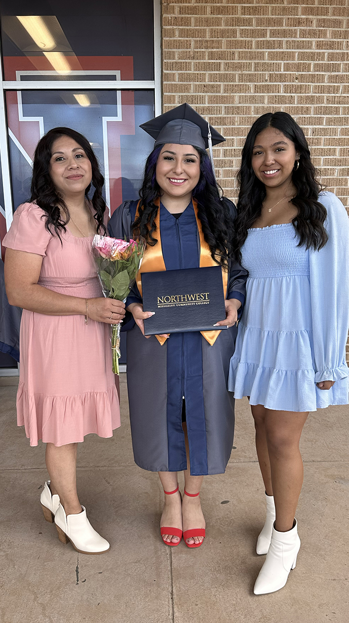 Salazar takes a photo at her community college graduation with her mother and sister.